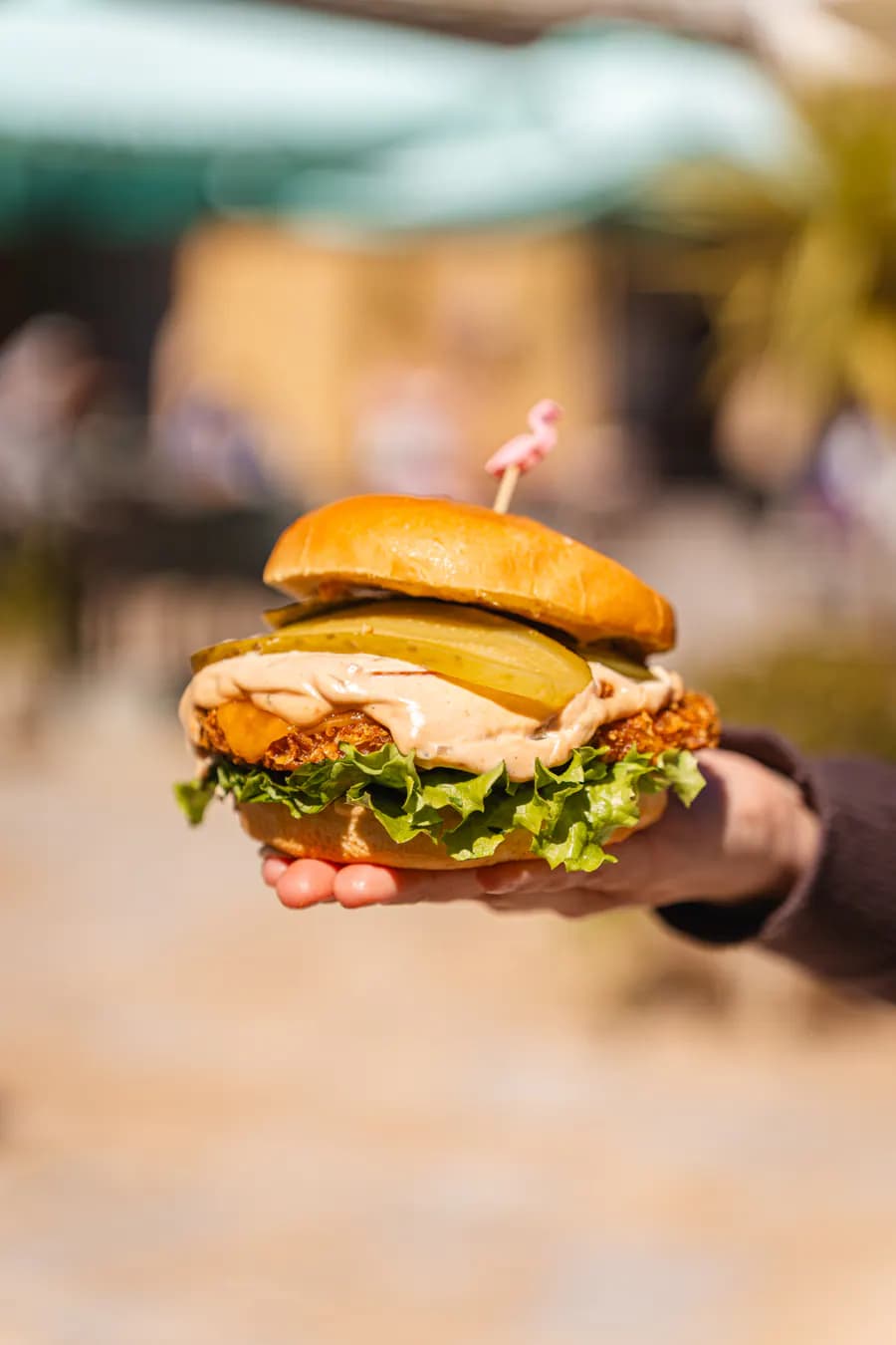 Dito Crispy Burger in den Händen gehalten